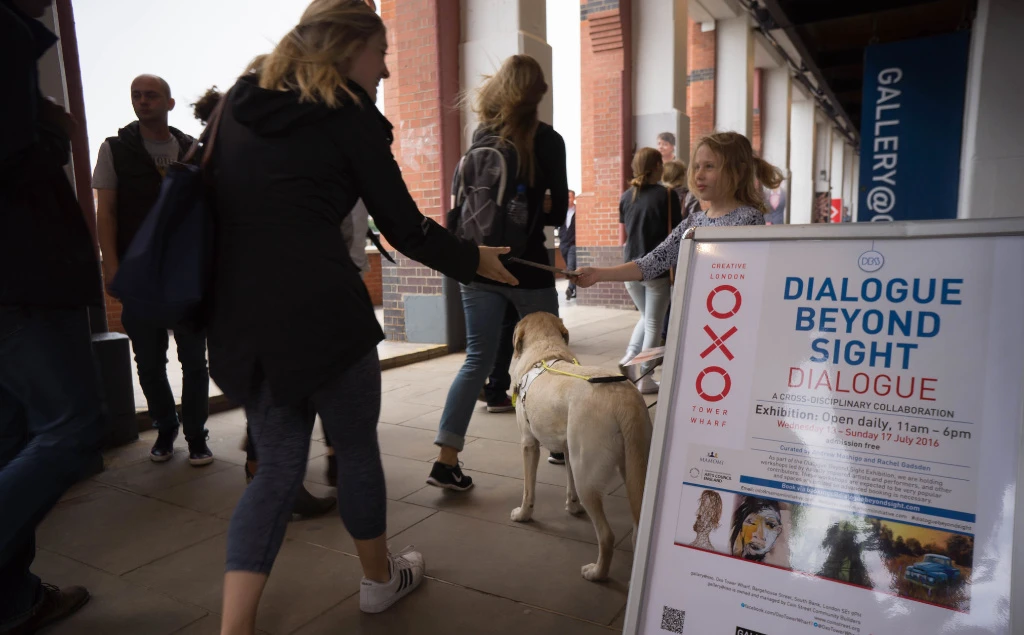 A young girl handing out flyers for the exhibition.