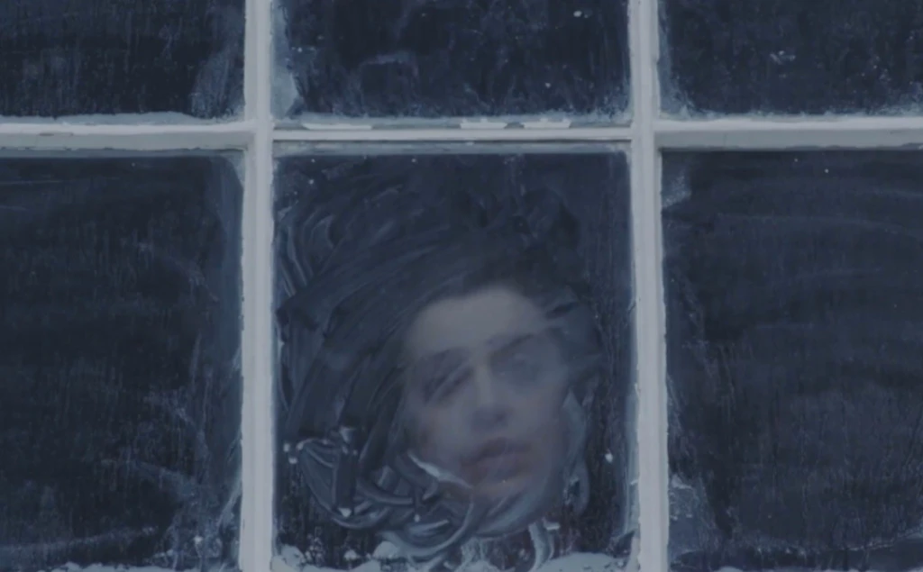 Girl looking through a foggy window.