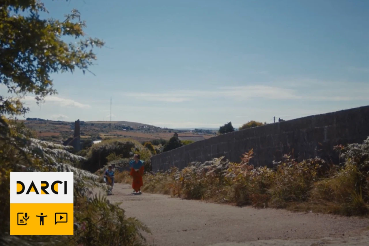 ‘A girl and a boy are walking up a road in the countryside. A frame from the film Spines.’