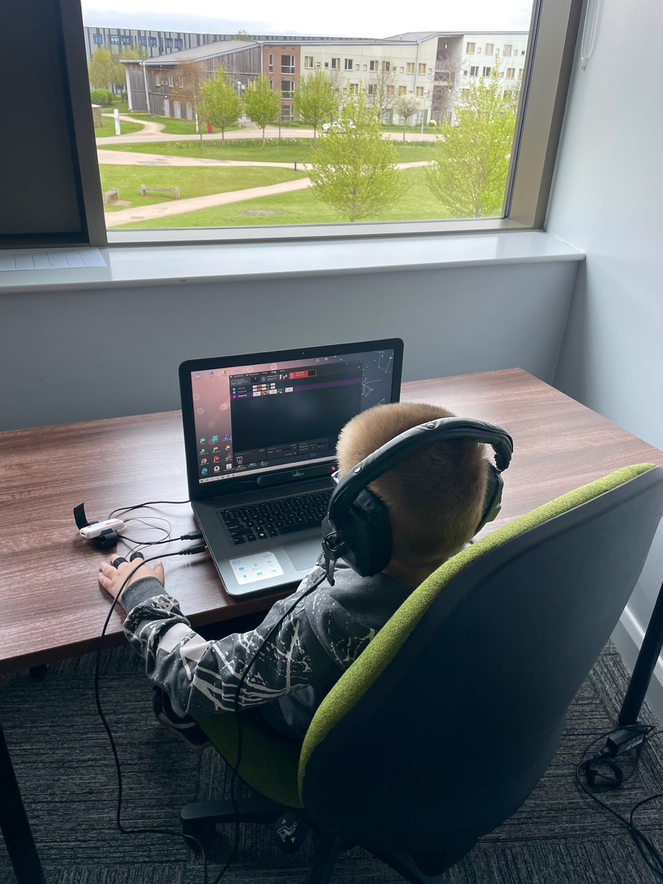 A child in front of a computer with headphones.