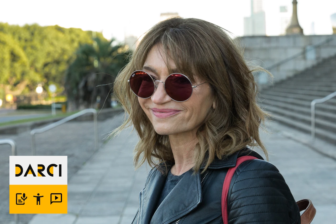 Medium shot of Gabi with sunglasses on street.
