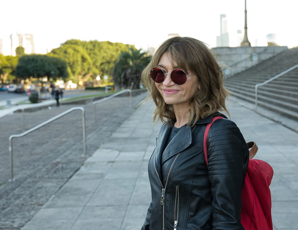 Medium shot of Gabi with sunglasses on street.