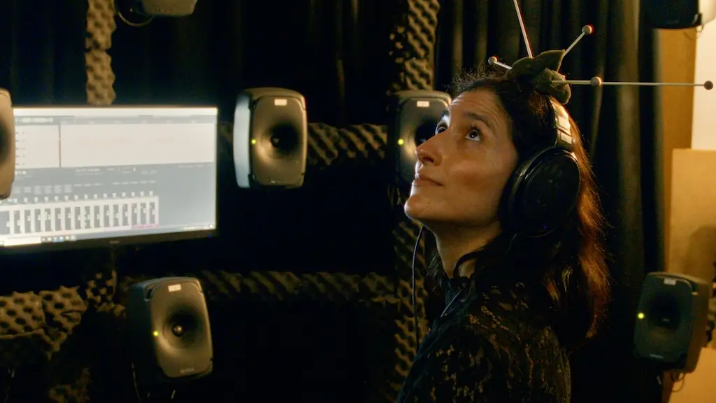 Mariana sitting in front of a computer screen with a measuring device on her head.