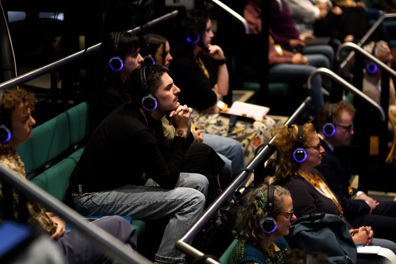 People sitting with headphones in the theatre.